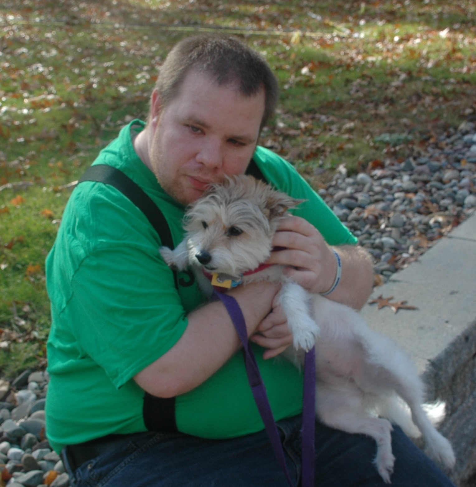 A man holding his dog lovingly